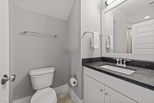 bathroom featuring lofted ceiling, vanity, toilet, and a shower with door