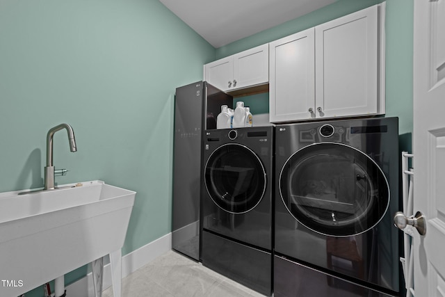 laundry room with cabinets, separate washer and dryer, and sink