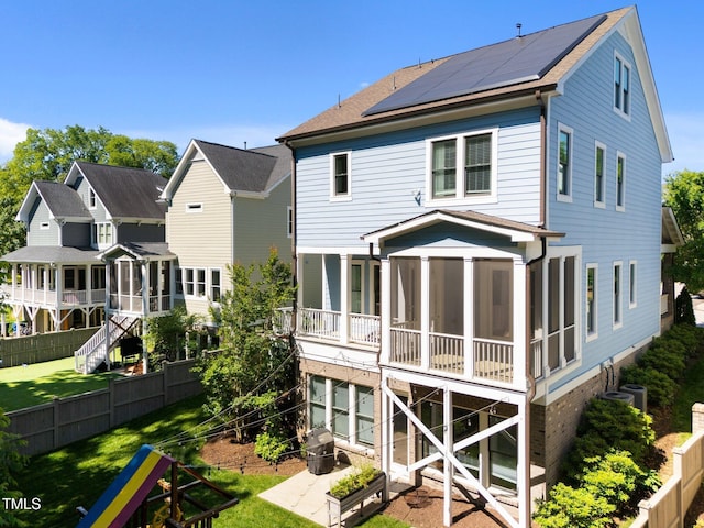 1000 Norris St, Raleigh, NC 27604 - back of house featuring a sunroom, solar panels, roof with shingles, and central AC