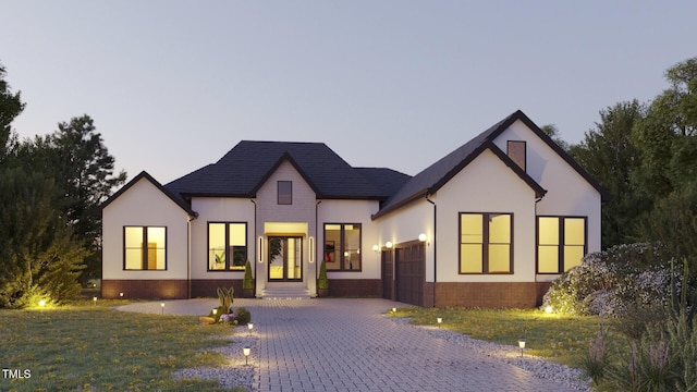 view of front of home with a garage and a lawn