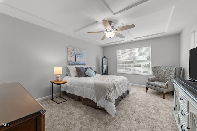 carpeted bedroom with a tray ceiling and ceiling fan