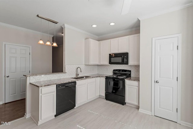 kitchen with sink, black appliances, white cabinets, decorative light fixtures, and kitchen peninsula