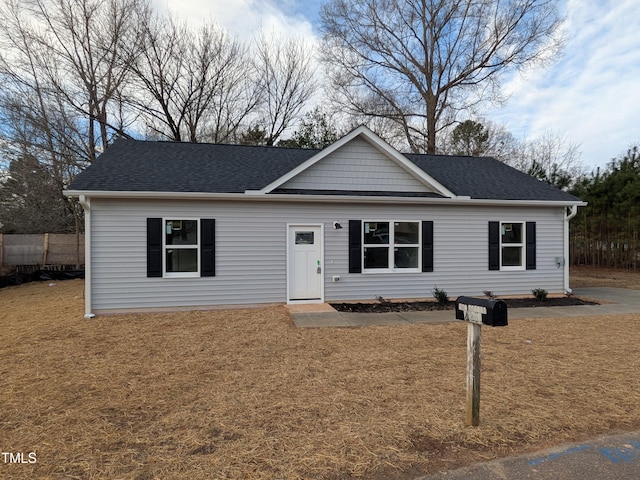 ranch-style house featuring a front yard and a shingled roof