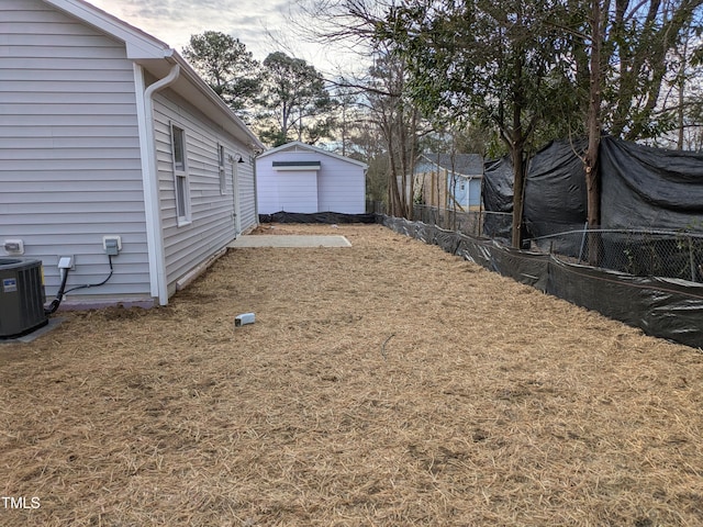 view of yard featuring central AC unit and fence