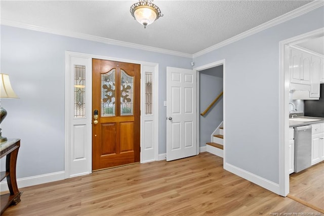 entryway featuring a textured ceiling, crown molding, light hardwood / wood-style flooring, and sink