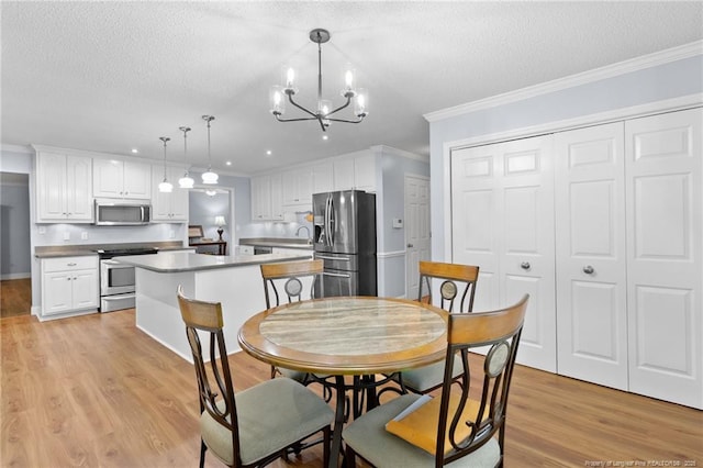 dining space featuring a textured ceiling, crown molding, and a chandelier