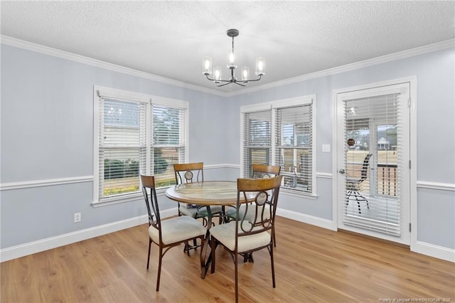 dining area featuring light wood-type flooring, an inviting chandelier, and a textured ceiling