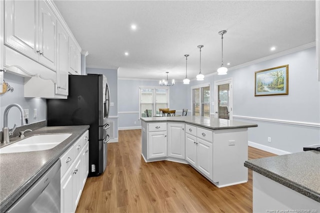 kitchen featuring appliances with stainless steel finishes, white cabinetry, a kitchen island, and sink