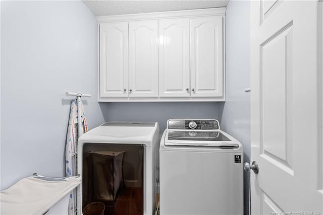 washroom with cabinets and washer and clothes dryer