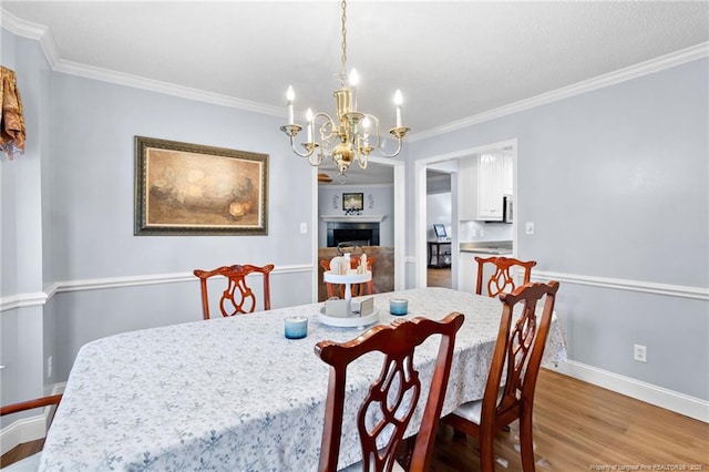 dining area featuring an inviting chandelier, crown molding, and hardwood / wood-style flooring