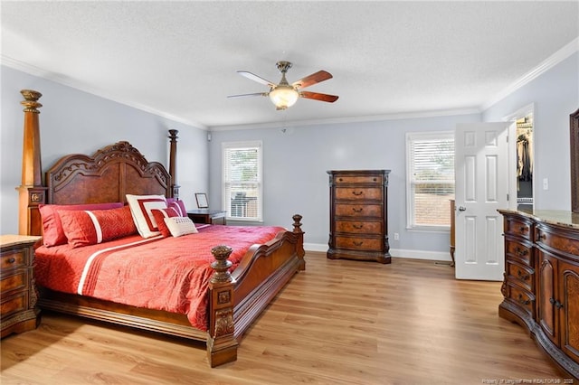 bedroom featuring ceiling fan, a walk in closet, a closet, and ornamental molding