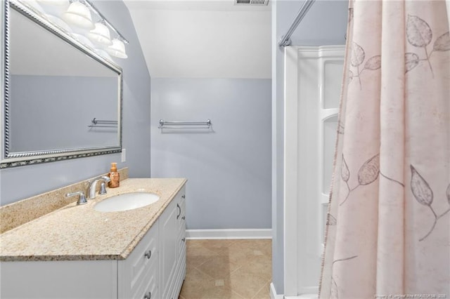 bathroom with vaulted ceiling and vanity