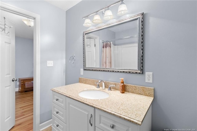 bathroom with vanity, curtained shower, and hardwood / wood-style floors