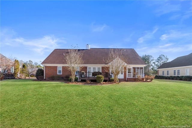 back of property featuring a deck and a lawn