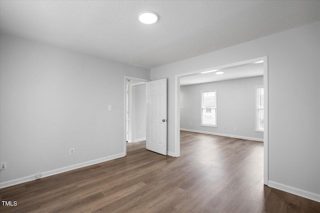 empty room featuring dark wood-type flooring and a textured ceiling