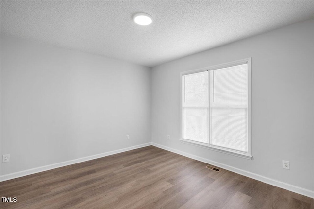 spare room with hardwood / wood-style flooring and a textured ceiling