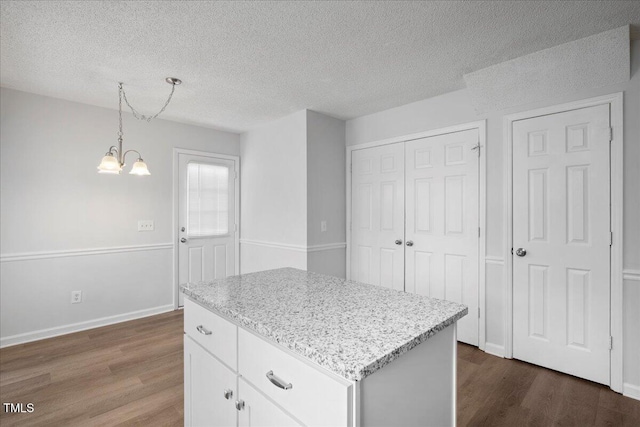 kitchen featuring white cabinetry, hanging light fixtures, dark hardwood / wood-style flooring, and a center island