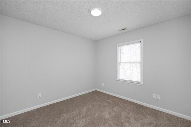 carpeted spare room featuring a textured ceiling