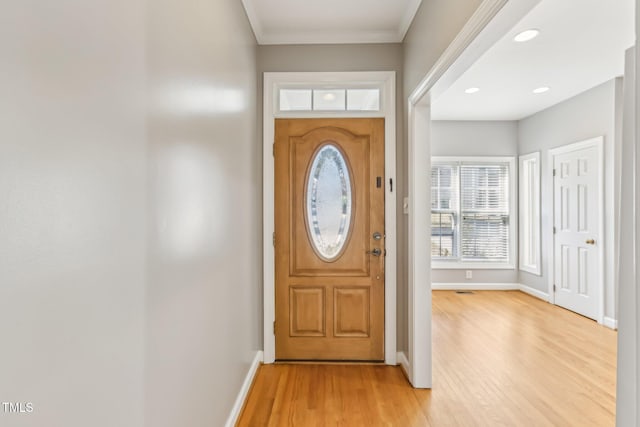 doorway to outside with crown molding and light wood-type flooring