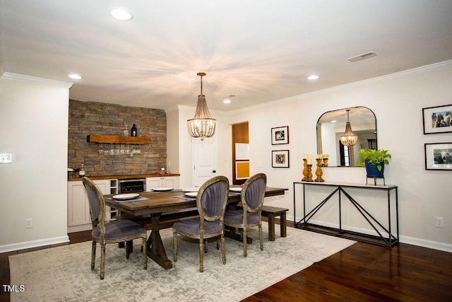 dining space featuring hardwood / wood-style flooring, ornamental molding, a chandelier, and wine cooler