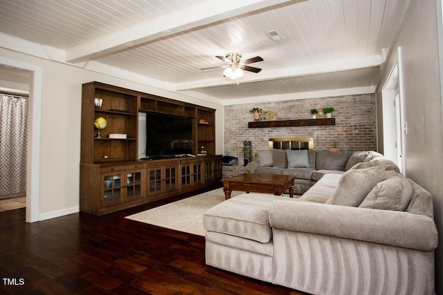 living room with beamed ceiling, ceiling fan, dark hardwood / wood-style floors, and a fireplace