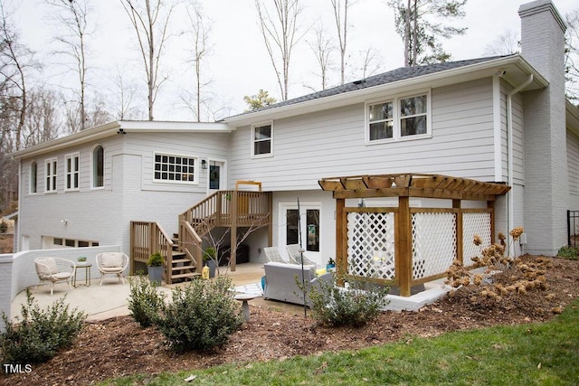 rear view of house featuring a pergola and a patio area