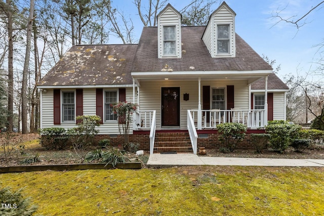 cape cod-style house with a front yard and covered porch