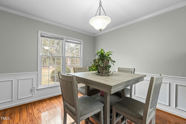 dining area featuring ornamental molding and wood-type flooring