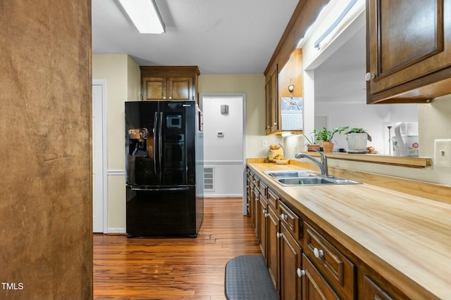 kitchen featuring wood counters, sink, black fridge with ice dispenser, and dark hardwood / wood-style floors