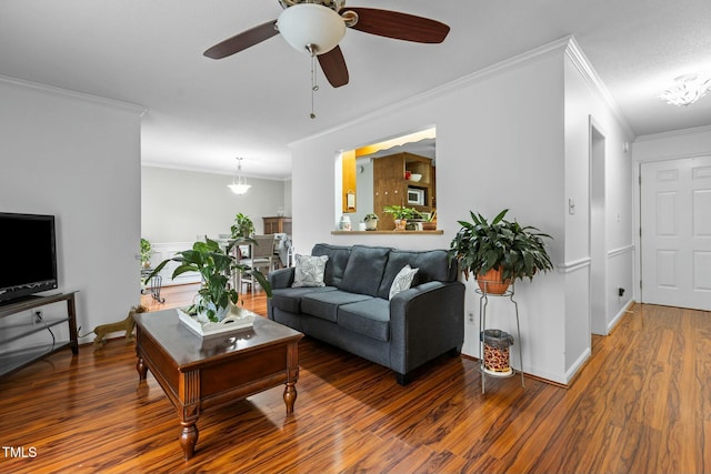 living room with crown molding, dark wood-type flooring, and ceiling fan