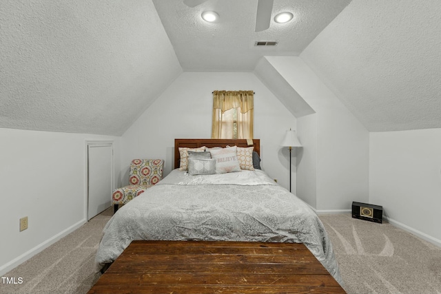 carpeted bedroom featuring lofted ceiling and a textured ceiling