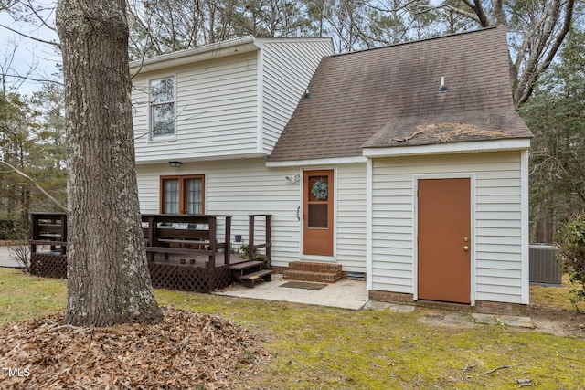 view of front of property featuring cooling unit and a front lawn