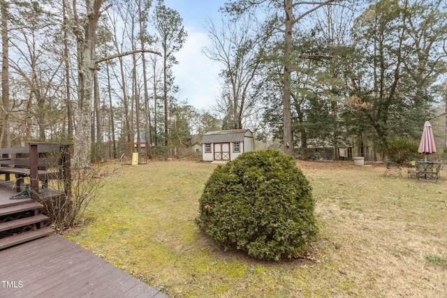 view of yard featuring a wooden deck and a storage shed