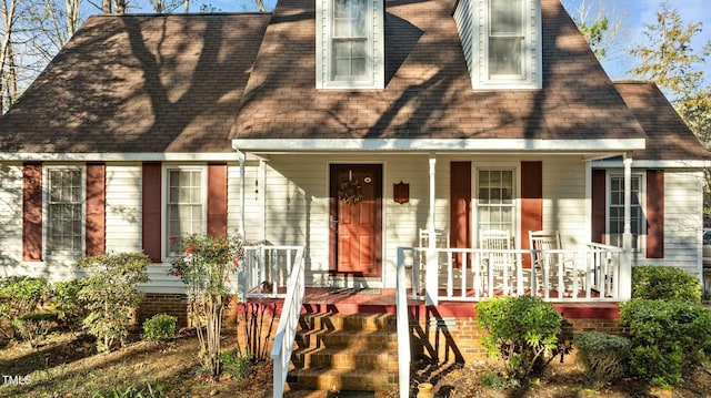 cape cod house featuring covered porch