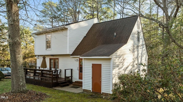 rear view of house featuring a wooden deck