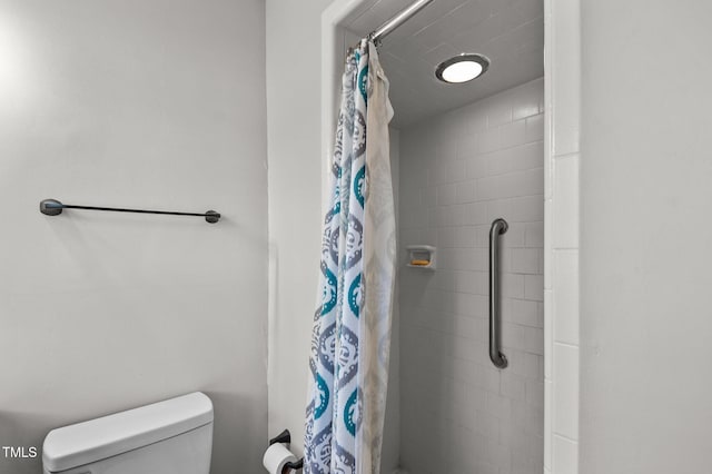 bathroom featuring toilet and a shower with curtain