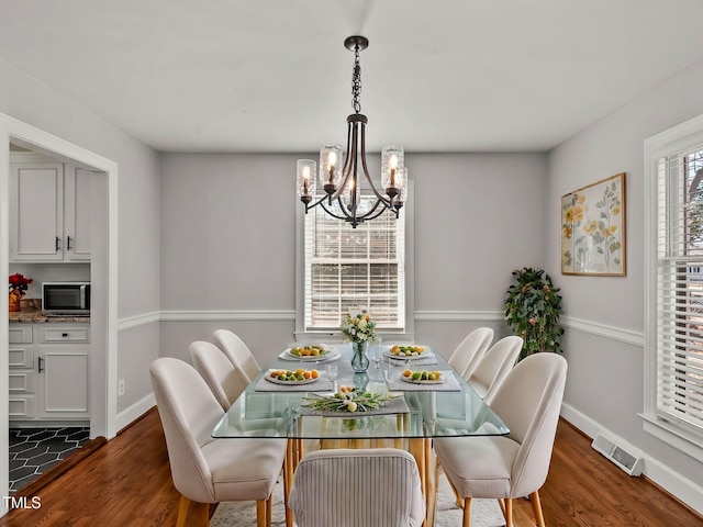 dining room featuring dark wood-type flooring and a notable chandelier