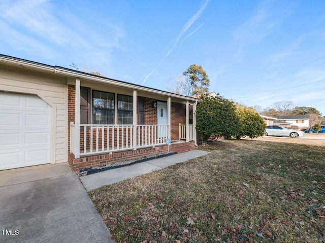 single story home with a garage, a front lawn, and a porch