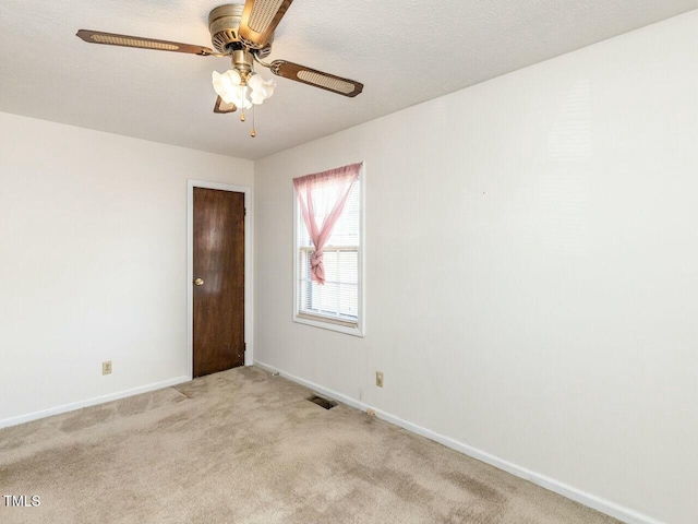 carpeted empty room with ceiling fan and a textured ceiling