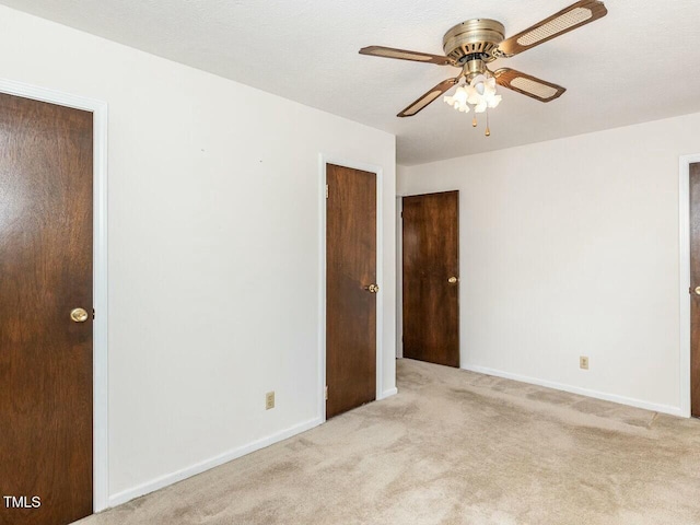 unfurnished room with light colored carpet, a textured ceiling, and ceiling fan