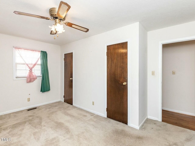 unfurnished bedroom with ceiling fan and light carpet