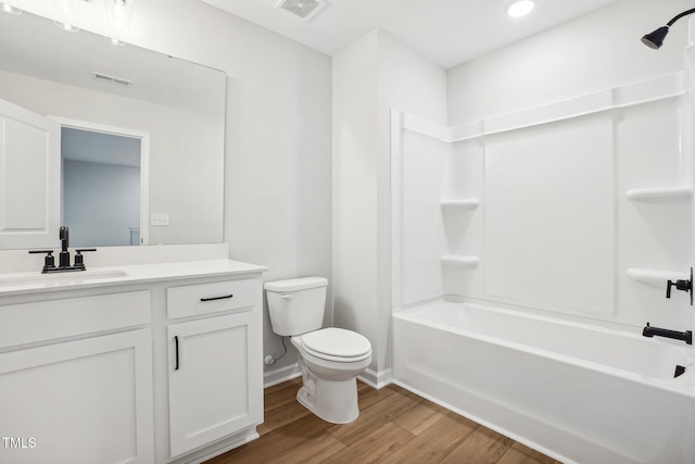 full bathroom with tub / shower combination, hardwood / wood-style flooring, toilet, and vanity