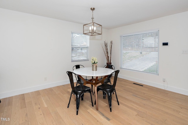 dining area with a chandelier and light wood-type flooring