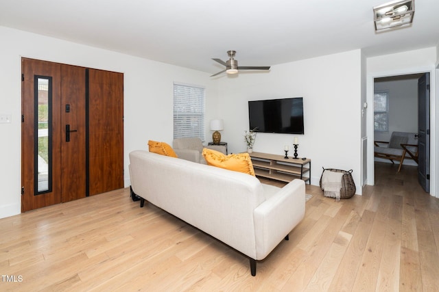 living room with ceiling fan and light hardwood / wood-style flooring