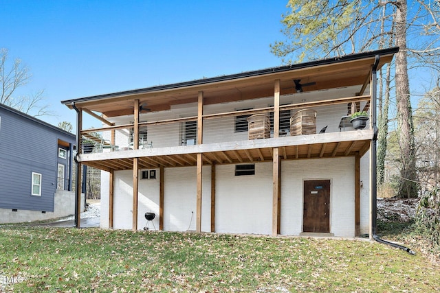 back of property with a yard and ceiling fan