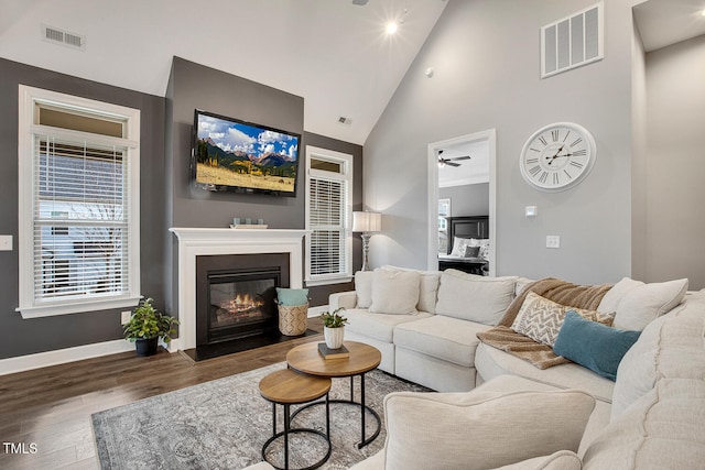 living room featuring dark hardwood / wood-style flooring and high vaulted ceiling