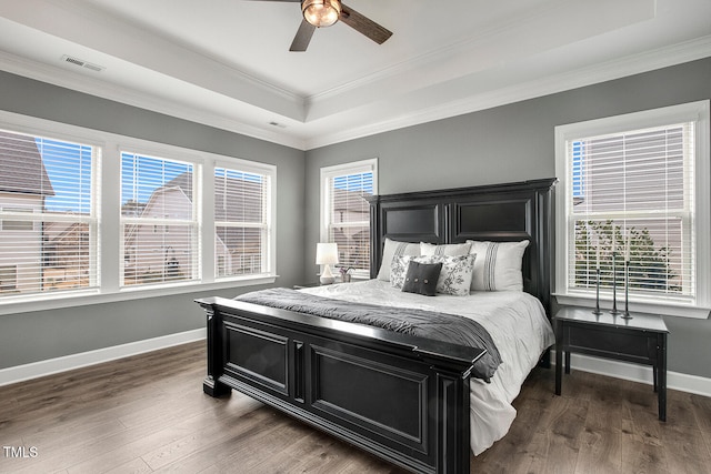 bedroom featuring crown molding, dark hardwood / wood-style floors, a raised ceiling, and ceiling fan