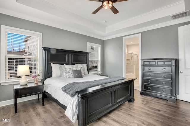 bedroom featuring a raised ceiling, ornamental molding, and hardwood / wood-style floors