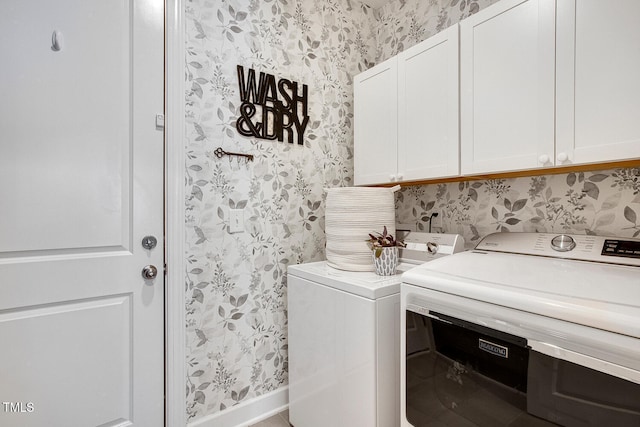 laundry room with washing machine and dryer and cabinets