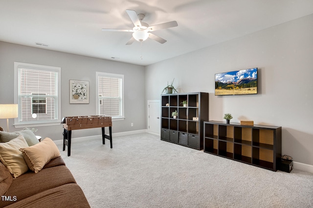 carpeted living room with ceiling fan